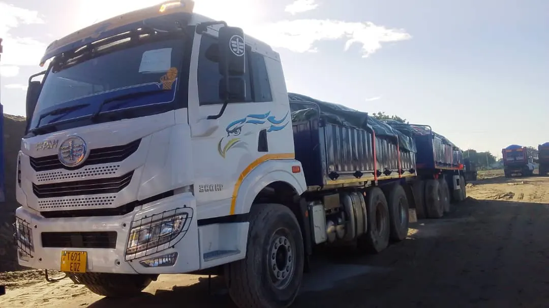 White Floregine FAW truck with covered trailers on site