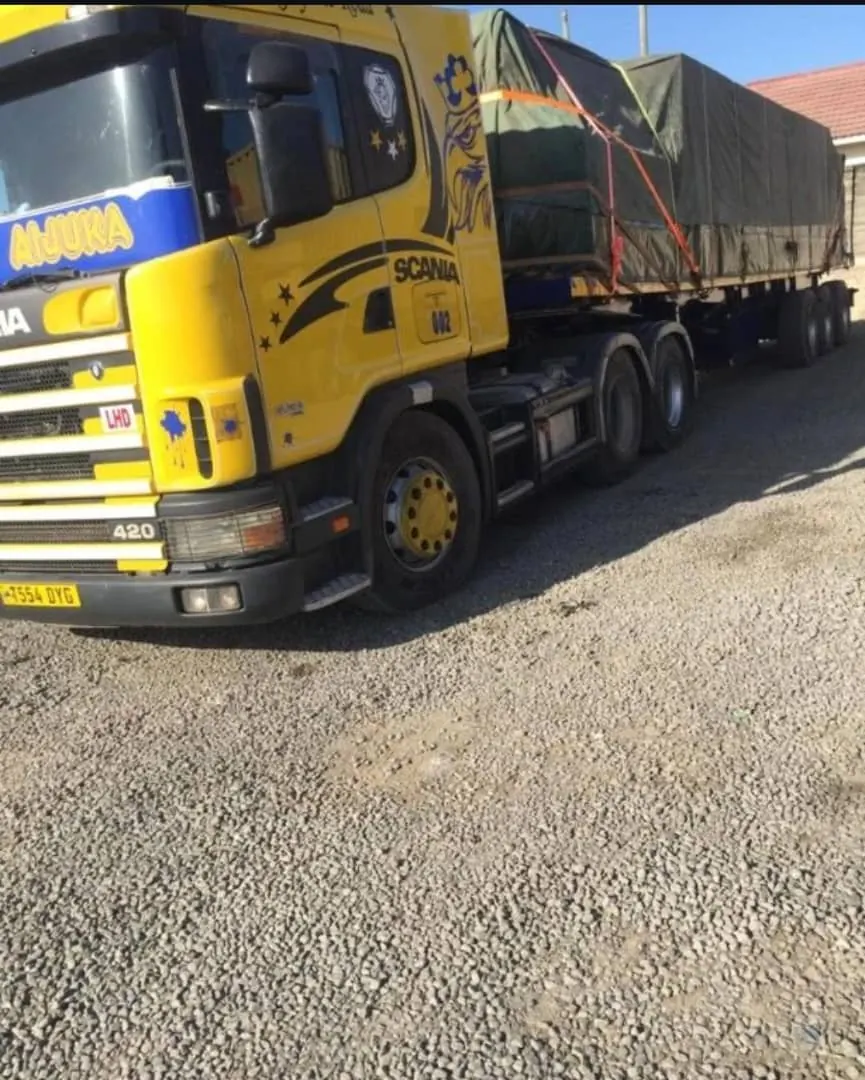 Yellow Floregine Scania truck carrying covered cargo